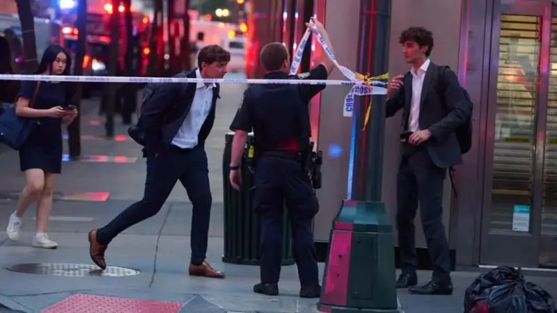 View of a New York City building where Shane Tamura attacked, with police vehicles and caution tape around the area